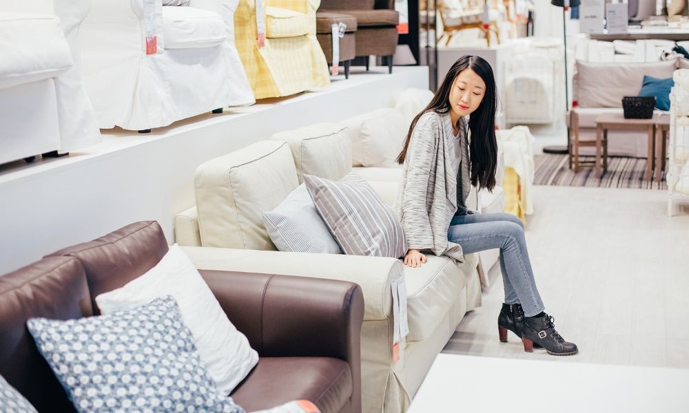 A long hair lady sitting in a sofa and feel the material