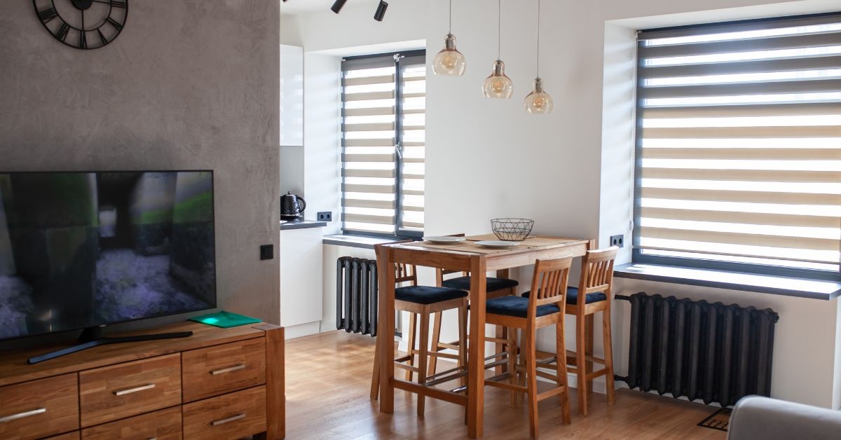 Two young ladies talking one holding a book another with box in a collge dorm